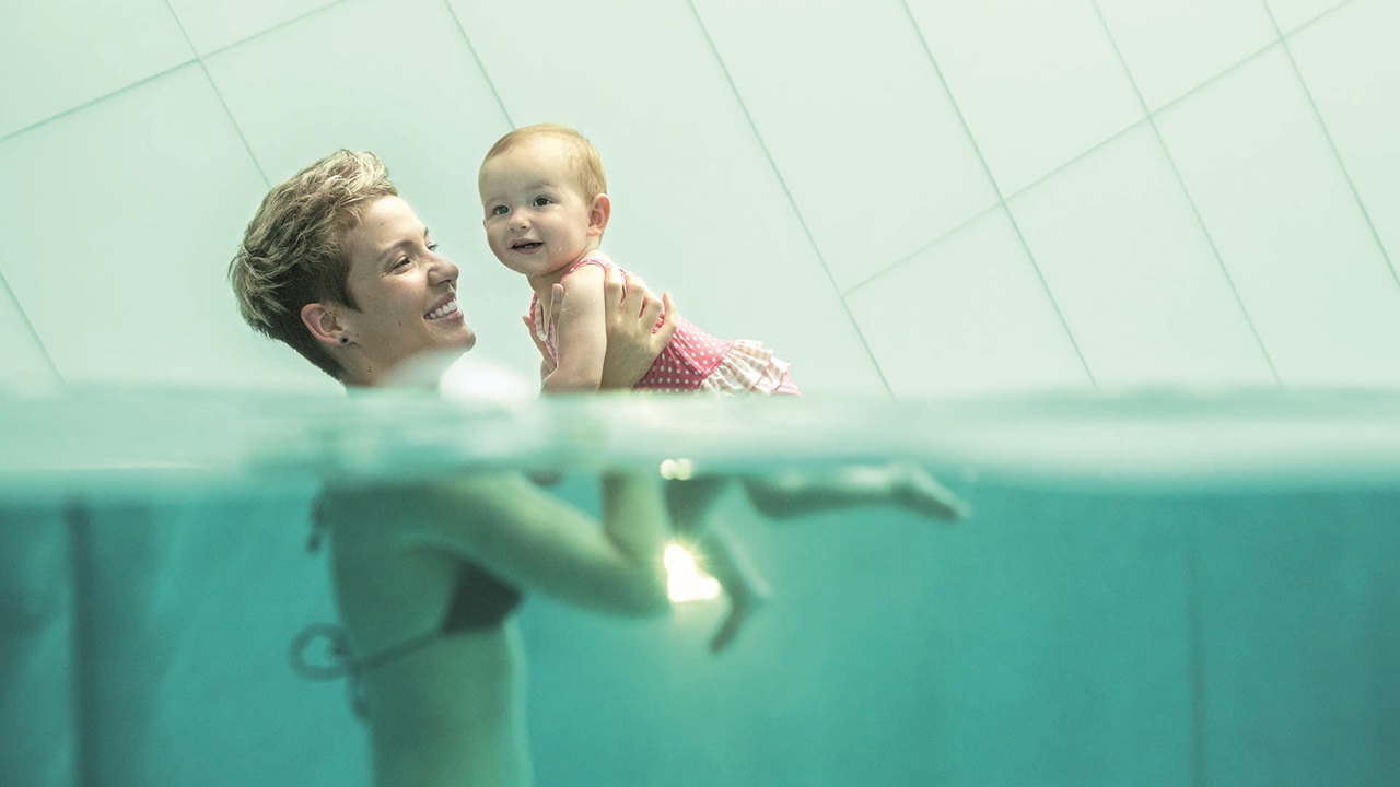 Femme avec son bébé dans l'eau.